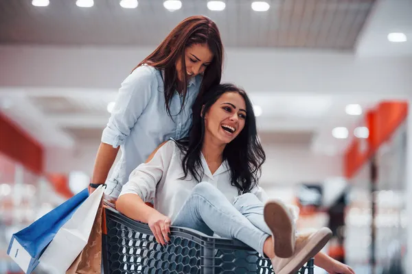 Twee Jonge Vrouwen Hebben Plezier Door Rennen Rijden Winkelmand Supermarkt — Stockfoto
