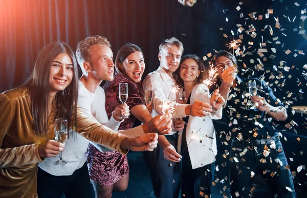 キラキラと楽しいですね コンフェッティが空中にいる お酒を片手に年末年始をお祝いする陽気な友達のグループ — ストック写真
