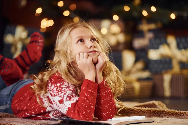 Cute Little Girl Czerwonym Swetrze Świątecznym Pomieszczeniach Leżących Świętując Nowy — Zdjęcie stockowe