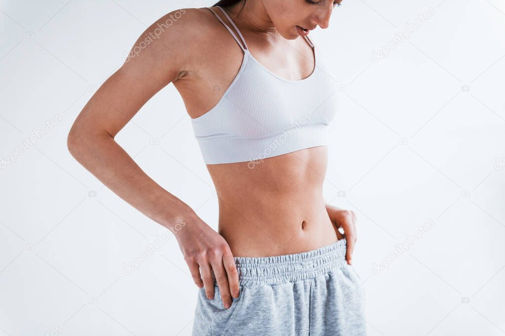Close up view of woman in underwear and with nice body shape in the studio against white background.
