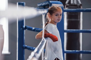 Boks ringinde. Spor kıyafetli küçük kız spor salonunda. Egzersiz günü..