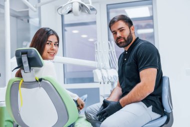 Neşeli kadının dişçi kliniğine bir ziyareti var. Stomatoloji kavramı.