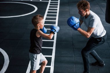 Genç antrenör spor salonunda çocuklara boks öğretiyor..