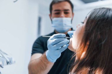 Genç yetişkin bir kadın dişçi kliniğine gidiyor. Stomatoloji kavramı.