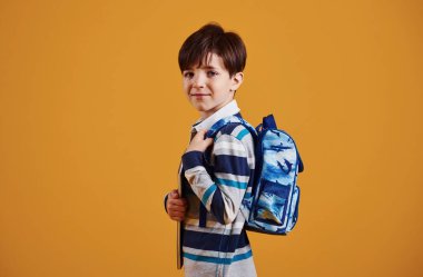 Stüdyoda sarı arka planda genç ve zeki bir öğrencinin portresi..