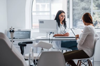 Aktif konuşma. Hamile kadın içeride kadın doğum uzmanıyla görüşüyor..