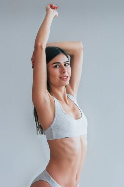 İç çamaşırlı güzel esmer kız stüdyoda beyaz arka planda..