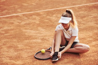 Hazırlanıyor. Spor elbiseli genç tenisçi dışarıda..