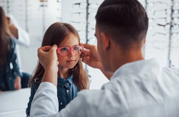 Jovem Pediatra Casaco Branco Ajuda Obter Novos Óculos Para Menina — Fotografia de Stock