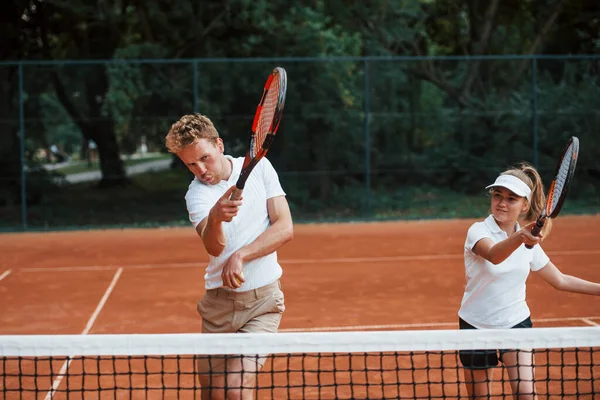 スポーツユニフォームを着た2人がコートでテニスをする — ストック写真