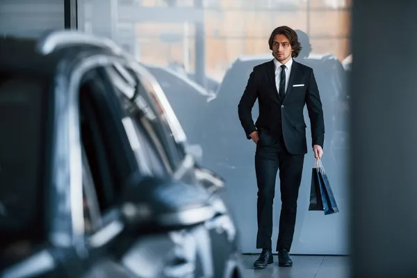 양복을 넥타이를 현대식 자동차 근처에 쇼핑백을 잘생긴 사업가의 — 스톡 사진