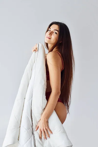 白い背景を持つスタジオでタオルで彼女の体を覆う女性 — ストック写真