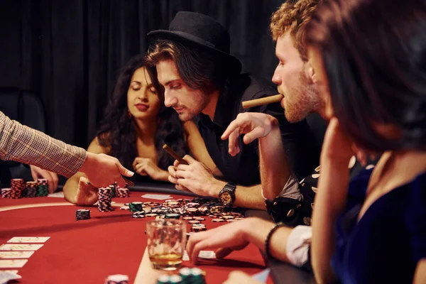 グラスを飲みながら 一緒にカジノでポーカーをプレイエレガントな若者のグループ — ストック写真