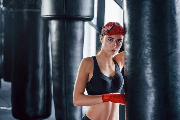 Young woman in sportive wear is in the gym having exercise day. Conception of boxing.