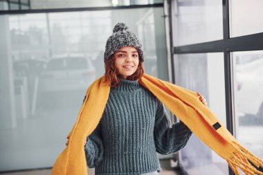 Sarı eşarplı, sıcak elbiseli, güzel, neşeli bir kız..