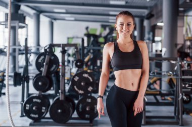 Spor salonunda duran not defterli genç bayan fitness antrenörü..