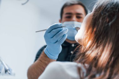 Genç yetişkin bir kadın dişçi kliniğine gidiyor. Stomatoloji kavramı.