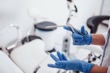 Retraktör aletini tutan kadın doktor ellerine yakından bakın..