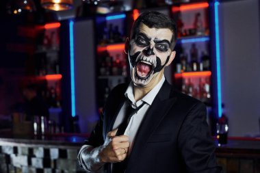 Kameraya bağırıyordu. Korkunç iskelet makyajı ve kostümlü tematik cadılar bayramı partisindeki adamın portresi..