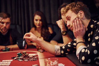 Adam arabasıyla bahis oynuyor. Kumarhanede birlikte poker oynayan bir grup zarif genç..