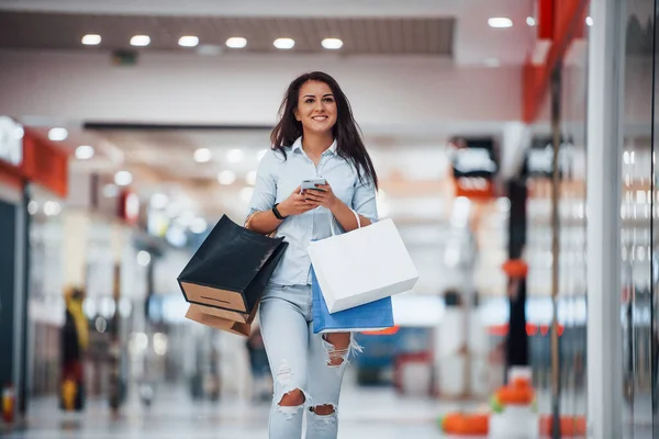 Brunetka Kobieta Supermarkecie Wieloma Pakietami Telefon Rękach Mają Dzień Zakupów — Zdjęcie stockowe