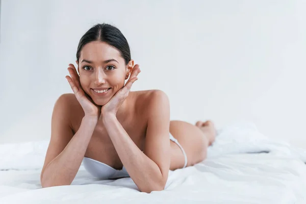 Mulher Sorrindo Positivo Roupa Interior Deitado Estúdio Contra Fundo Branco — Fotografia de Stock