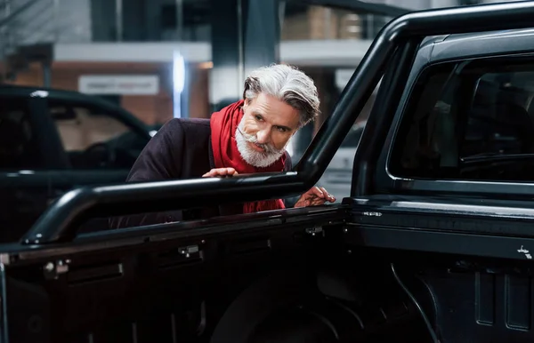 时髦的老人 白发苍苍 留着胡子 正在客厅里找一辆新车 — 图库照片
