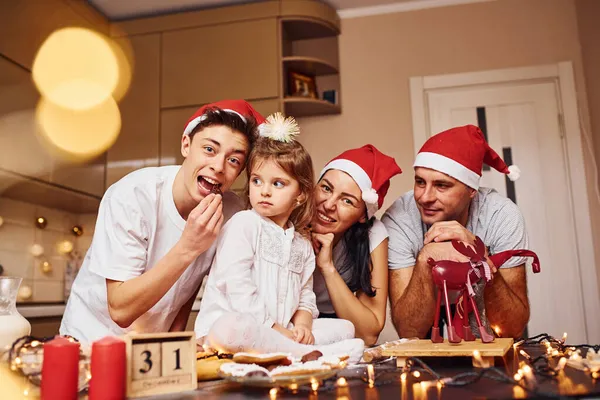 クリスマスの帽子の祭りの家族はキッチンで楽しみ 食べ物を準備する — ストック写真