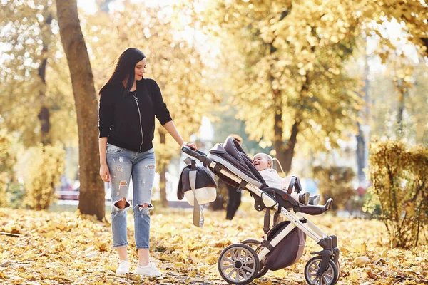 Matka Ubraniach Casual Dzieckiem Wózku Jest Pięknym Jesiennym Parku — Zdjęcie stockowe