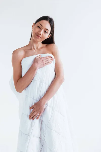 若いです女性カバー彼女の体にタオルでスタジオで白の背景 — ストック写真