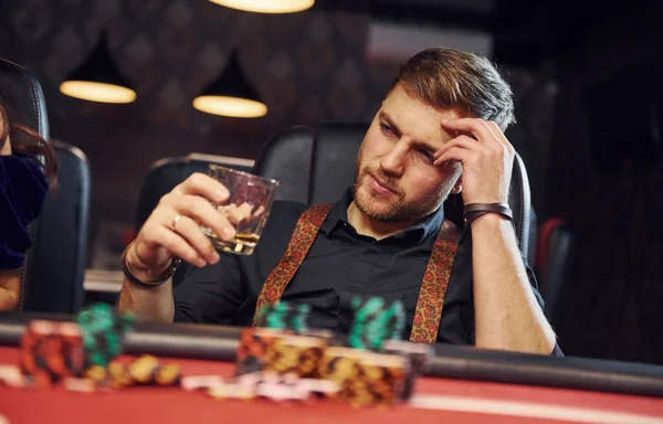 Элегантный Молодой Человек Стаканом Алкоголя Сидит Казино Играет Покер — стоковое фото