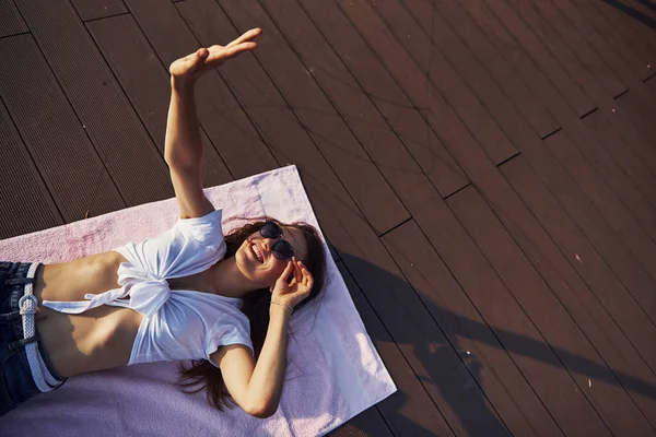 ビーチの陽気な女の子が地面に横になり 暖かい日差しを楽しんで — ストック写真