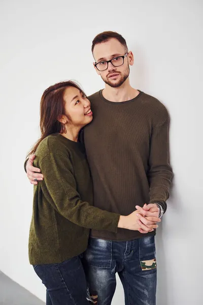 穿着休闲装的快乐的多种族夫妇一起在工作室的室内 有亚洲女朋友的白人男人 — 图库照片