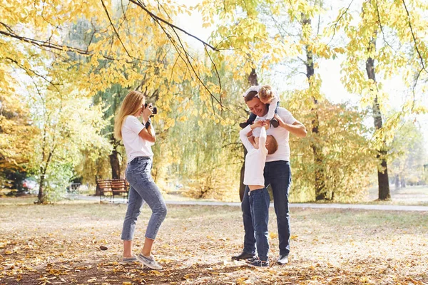 快乐的年轻家庭一起在秋天的公园里散步 — 图库照片