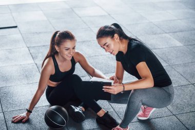 Not defteri olan bayan kişisel antrenör genç bayana sonuçları gösteriyor..