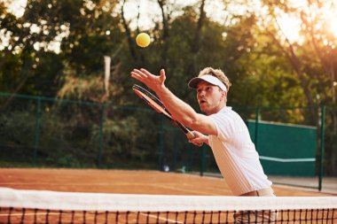 Spor elbiseli genç tenisçi dışarıda..
