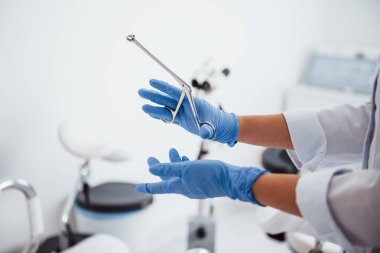 Retraktör aletini tutan kadın doktor ellerine yakından bakın..
