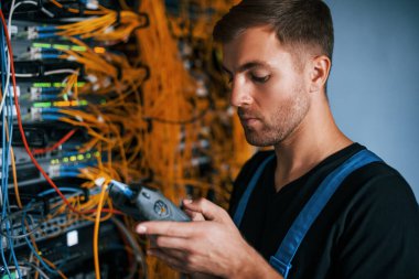 Üniformalı genç adamın sunucu odasında internet teçhizatı ve dinleme cihazlarıyla ilgili bir işi var..