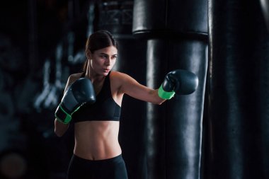 Spor kıyafetli genç bir kadın spor salonunda egzersiz yapıyor. Boks kavramı.