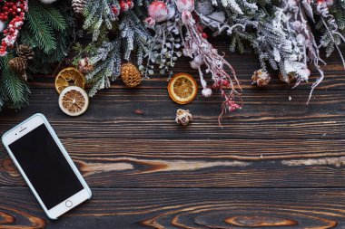Telefon masanın üstünde. Yeni yıl süslemeleri ile noel şenliği çerçevesinin en üst görünümü.