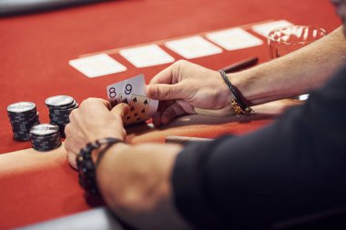 Kumarhanede poker oynayan zarif gençlerin ellerine yakından bakın..
