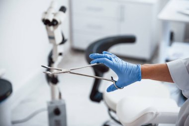 Forseps tutan kadın doktor ellerine yakından bakın..