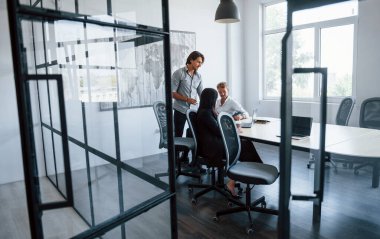 Ofiste çalışan resmi kıyafetli genç iş adamları..