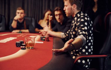 Kumarhanede poker oynayan bir grup zarif gencin yan görüntüsü..