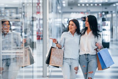 İki genç kadın süpermarkette alışveriş yapıyorlar..