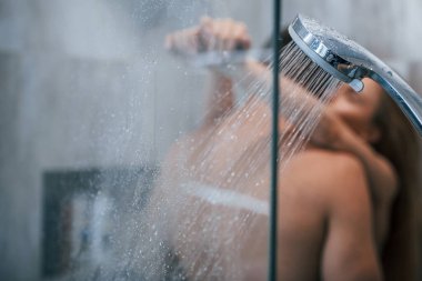 Banyoda birbirini kucaklayan ve öpen genç çiftin camından bakın..