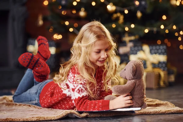 Schattig Klein Meisje Rood Feestelijk Truitje Liggend Met Teddybeer Binnen — Stockfoto