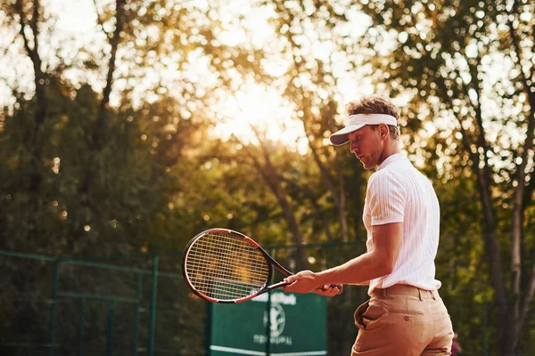 写真が動いてる スポーツウェアを着た若いテニス選手が屋外のコートにいます — ストック写真