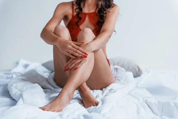Kırmızı Çamaşırlı Beyaz Yatakta Oturan Kadının Yakın Görüntüsü — Stok fotoğraf