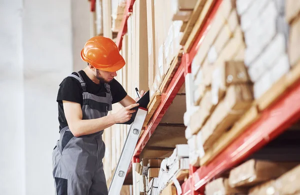 Trabalhador Armazenamento Fica Escada Uniforme Bloco Notas Mãos Verifica Produção — Fotografia de Stock